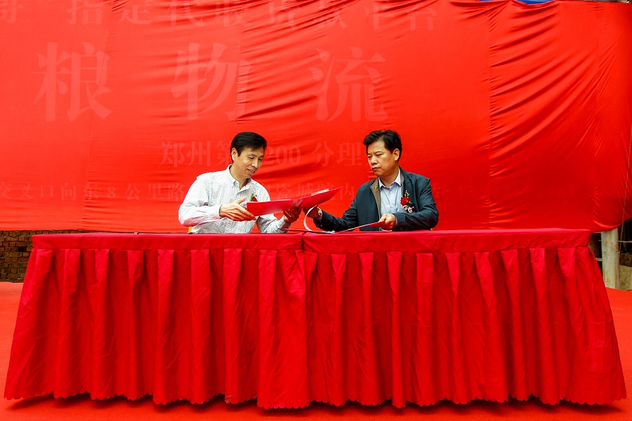 图5说：河南商报发展有限公司总经理孙国系与郑粮集团常务副总李金成签订战略合作协议